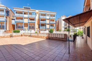a patio with an umbrella in front of a building at Lopimar Aurora in Canet de Berenguer