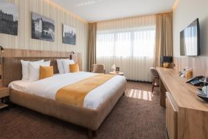 a hotel room with a large bed and a desk at Hotel Le 830 Namur in Namur