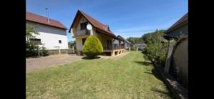 a house with a fence and a grass yard at Stella apartman in Gabčíkovo