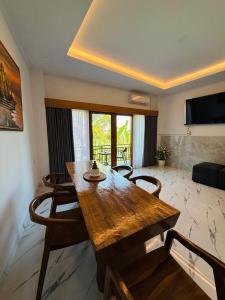 a living room with a wooden table and chairs at MEDEWI BREEZE House in Airsatang