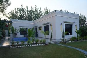 a white house with a garden in front of it at Angad Farms in Kharar