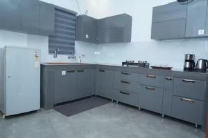 a kitchen with gray cabinets and a white refrigerator at Angad Farms in Kharar