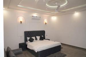 a bedroom with a bed and two lights on the ceiling at Angad Farms in Kharar