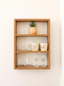a wooden shelf with glasses and a plant on it at Sunset studio in Plaka in Plaka Milou