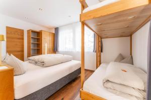 two bunk beds in a room with wooden floors at Elisabeth Appartements in Damuls