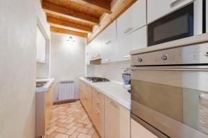 a kitchen with white cabinets and a stove top oven at Casa Dolce Casa Al Castello in Pozzolengo