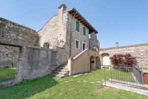 an old stone house with a gate and a yard at Casa Dolce Casa Al Castello in Pozzolengo