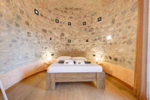 a bedroom with a bed and a stone wall at Casa Dolce Casa Al Castello in Pozzolengo