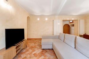 a living room with a white couch and a flat screen tv at Casa Dolce Casa Al Castello in Pozzolengo