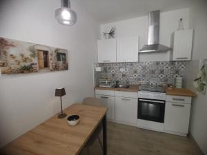 a kitchen with white cabinets and a wooden table at Studio apartman Marija 2 in Bol