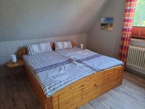 a bedroom with a wooden bed with a blue comforter at FeWo Petersen, Köhn in KÃ¶hn