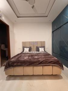a bedroom with a large bed with a brown blanket at Urban Nest By Jassi in Kharar