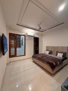 a bedroom with a bed and a television in it at Urban Nest By Jassi in Kharar +4 photos