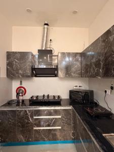 a kitchen with a black counter top and a stove at Urban Nest By Jassi in Kharar