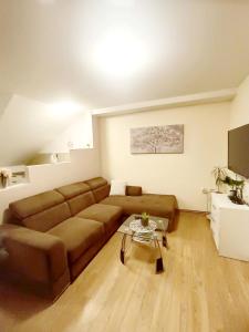 a living room with a brown couch and a table at Apartment Petra Zabok Horizon Suite in Zabok