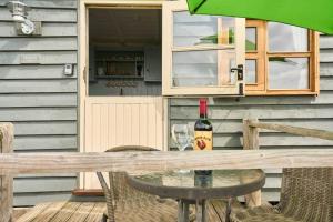 a table with a bottle of wine and a glass at Host & Stay - Shepherds View in Alburgh