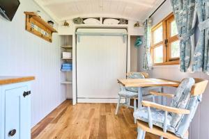 a kitchen with a table and chairs and a door at Host & Stay - Shepherds View in Alburgh
