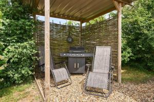 a barbecue with two chairs and a grill in a backyard at Host & Stay - Shepherds Delight in Alburgh