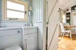 a bathroom with a sink and a window and a table at Host & Stay - Shepherds Delight in Alburgh