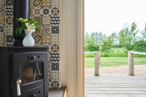 a fireplace with a vase of flowers on a wall at Host & Stay - Shepherds Delight in Alburgh