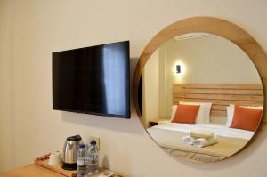 a mirror of a bedroom with a bed and a tv at Kale Otel Bodrum in Bodrum City