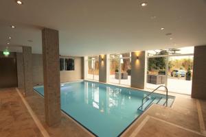 a large swimming pool in a building with a pool at Belgrave Sands Hotel & Spa in Torquay
