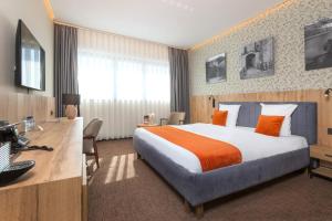 a hotel room with a bed and a desk at Hotel Le 830 Namur in Namur