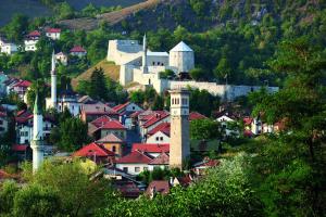 a small town with a clock tower on a hill at Apartment Alan - Modern Stay in Travnik
