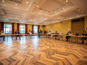 a group of people sitting at tables in a room at Plopsaland Theater Hotel in De Panne