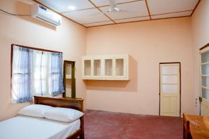 a bedroom with a bed and a window at Naga Vasa in Jaffna