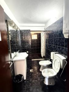 a bathroom with two toilets and a sink at Majka Guest House in Kotor