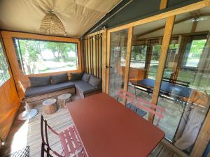 a living room with a table and chairs and a couch at Camping Onlycamp les Cochards in Seigy