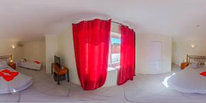 a living room with red curtains and a window at Hospedaria do Almargem in Quarteira
