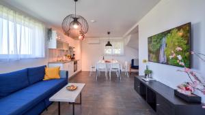 a living room with a blue couch and a kitchen at Villa Una by Villas Guide in Gornji Kneginec