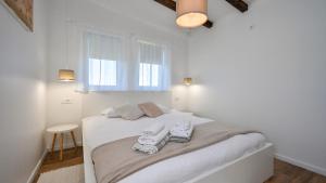 a white bedroom with a bed with towels on it at Villa Una by Villas Guide in Gornji Kneginec +25 photos