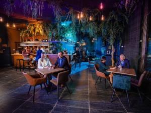 a group of people sitting at tables in a restaurant at Plopsaland Theater Hotel in De Panne