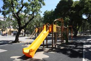 a playground with a yellow slide in a park at My Happy Place in Bari