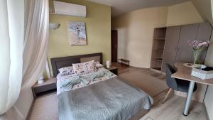 a bedroom with a bed and a desk and a table at Dimana in Chernomorets