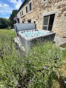 a bath tub sitting in the grass in front of a building at Le gîte d’Hayen in Sprimont