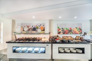 a kitchen with a counter with lots of food at Aparthotel Flora in Port de Pollensa +50 photos