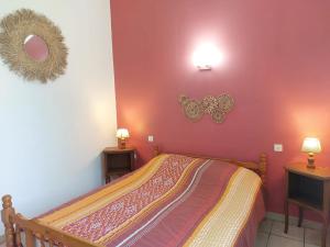 a bedroom with a bed and two mirrors on the wall at Le Cyprès - La Fontinelle in Bessas