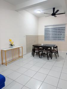 a dining room with a table and a ceiling fan at EQAMEL Homestay 2 in Sandakan