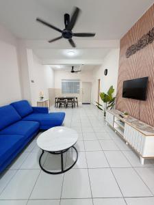 a living room with a blue couch and a table at EQAMEL Homestay 2 in Sandakan