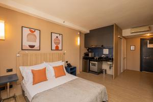 a hotel room with a bed and a kitchen at APS - Alpha Stay By Anora Spaces in Barueri