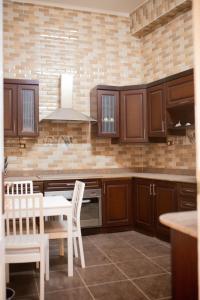 a kitchen with wooden cabinets and a table and chairs at Island House in Jazīrat Aswān