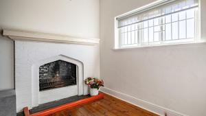 a living room with a fireplace with a vase of flowers at Adamastor Backpackers in Muizenberg