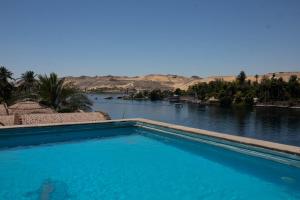 a swimming pool with a view of a river at Island House in Jazīrat Aswān