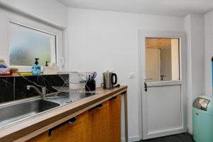 a kitchen counter with a sink and a window at Les terrasses de Joce in Batz-sur-Mer +21 photos