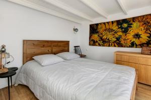 a bedroom with a bed and a painting on the wall at Les terrasses de Joce in Batz-sur-Mer