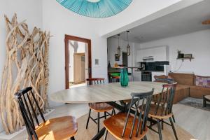 a dining room and living room with a table and chairs at Les terrasses de Joce in Batz-sur-Mer